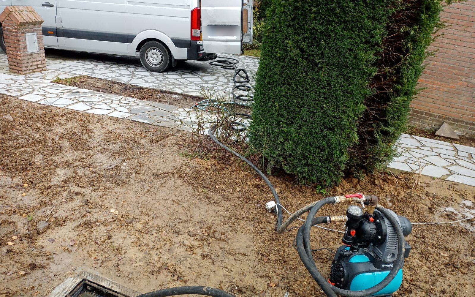 Débouchage d'égout en cours : flexibles déroulés depuis la camionnette jusqu'à la chambre de visite