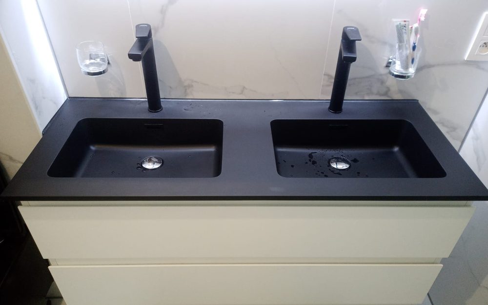 Double vasque noire encastrée sur meuble suspendu et robinetterie noire