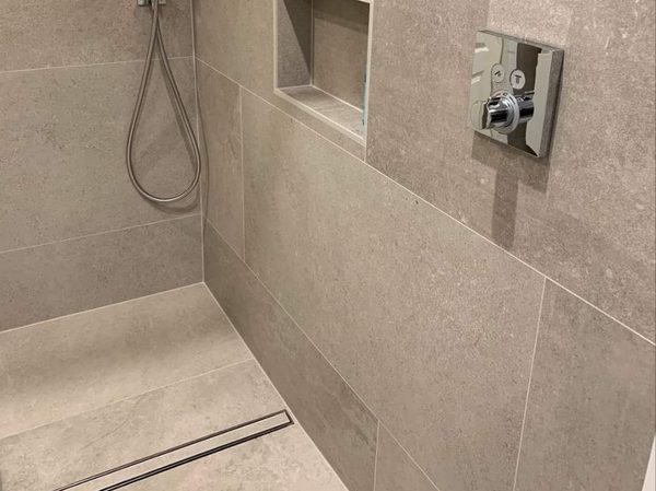 Douche à l'italienne avec caniveau encastré au ras du carrelage et niche murale