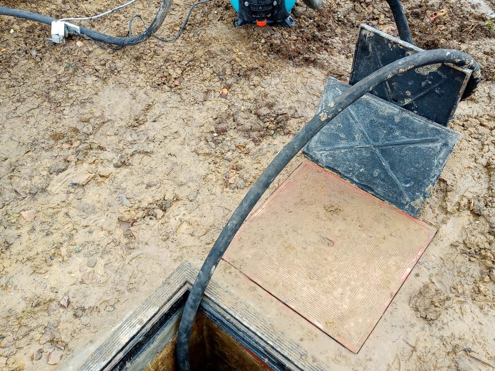 Pompe raccordée sur une chambre de visite pour vider l'égout avant intervention