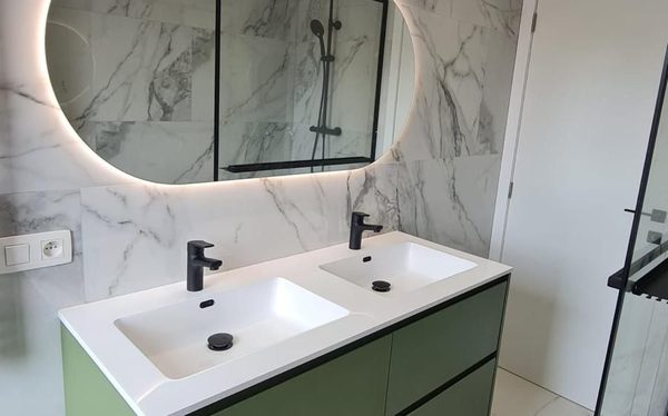 Salle de bain complète en marbre avec meuble vert et paroi de douche noire